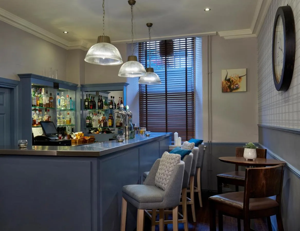 a bar in a restaurant with chairs and a table at Leonardo Edinburgh City in Edinburgh