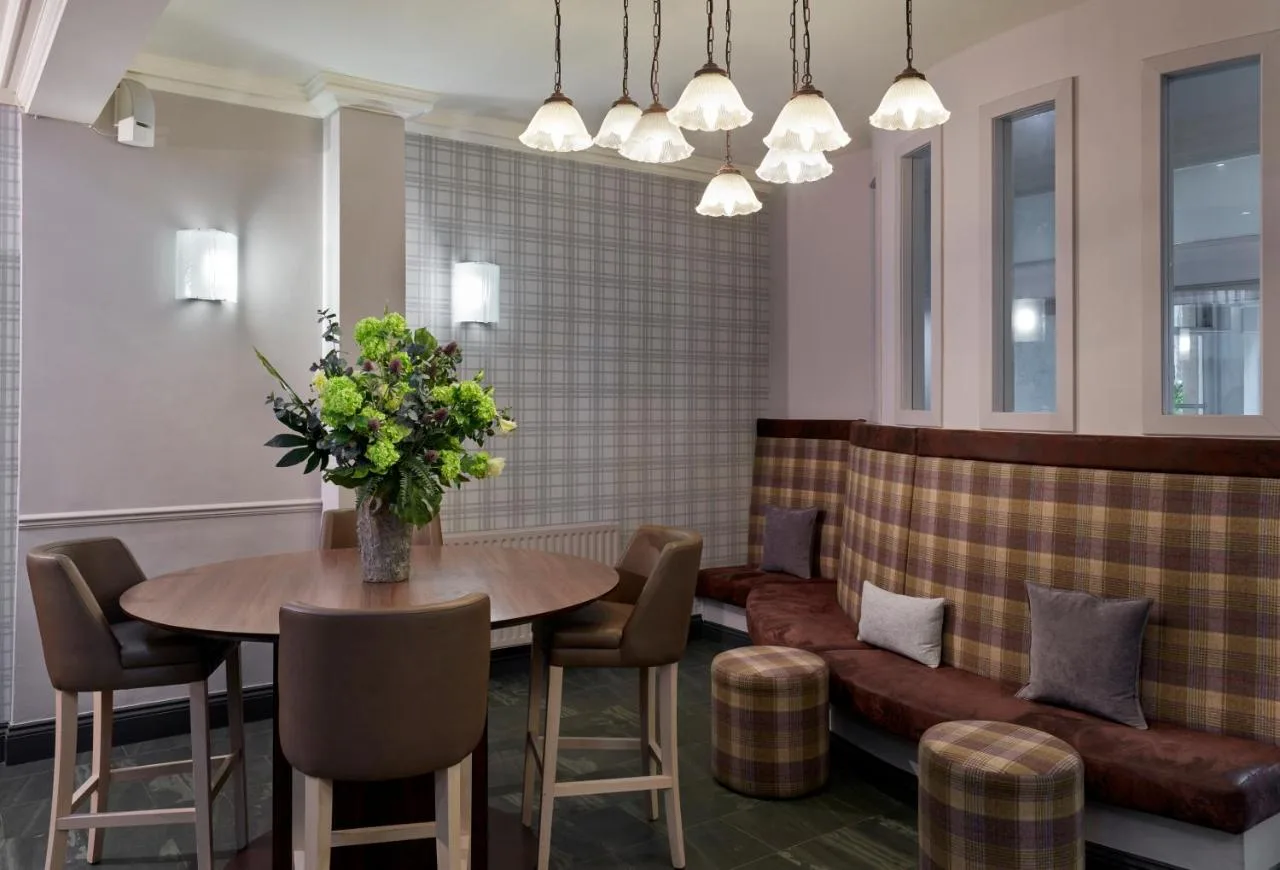 a dining room with a table and a couch at Leonardo Edinburgh City in Edinburgh