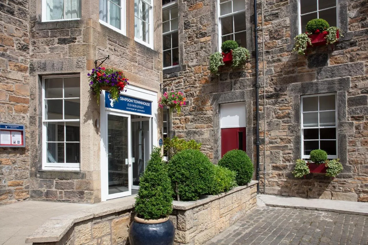 a brick building with potted plants and windows at Leonardo Edinburgh City in Edinburgh